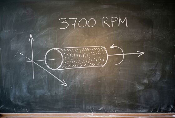Chalk sketch of a magnetic drum: a cylinder covered in rows of short marks, spinning on its axis, labelled 3700 RPM